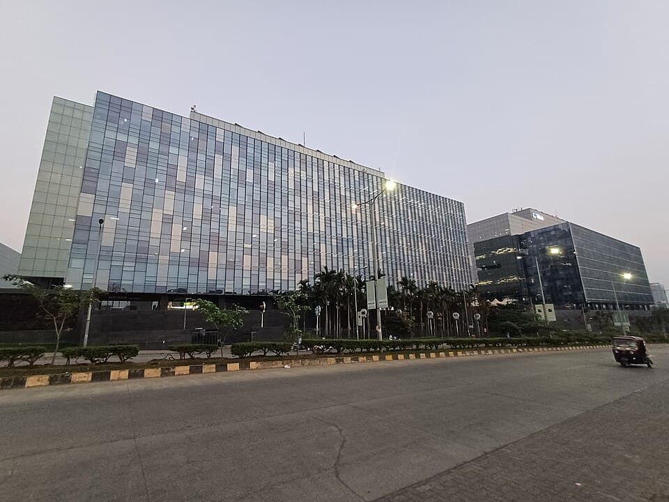 A glass-fronted office block on the main road through Kharadi, Pune, at dusk